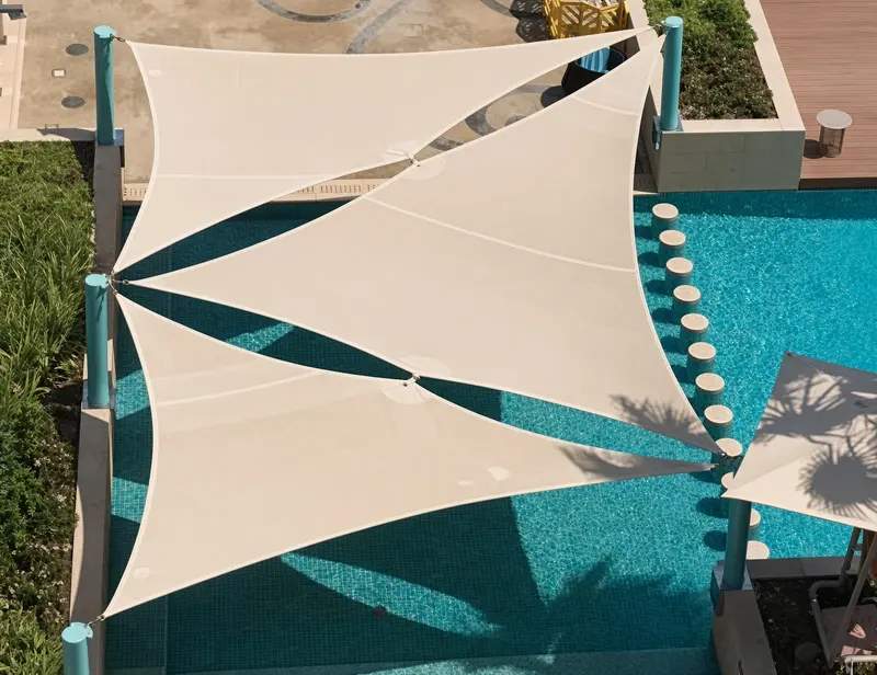 Shade sails stretched over a pool.